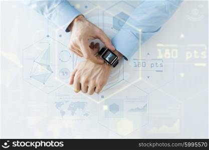 business, future technology and people concept - close up of male hands setting smart watch with virtual screens and charts projection