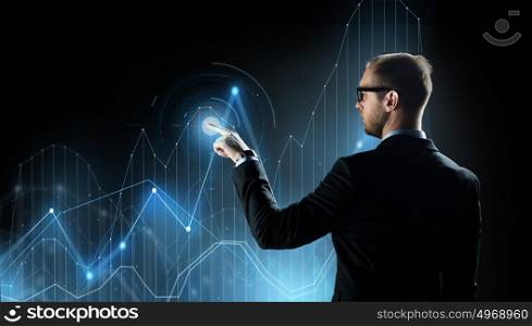 business, future technology, cyberspace and people - businessman in suit and glasses pointing finger to virtual diagram chart projection over black background. businessman with virtual diagram chart projection