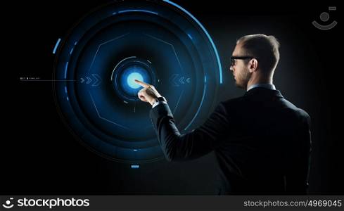 business, future technology, cyberspace and people - businessman in suit and glasses pointing finger to virtual projection over black background. businessman pointing finger to virtual projection