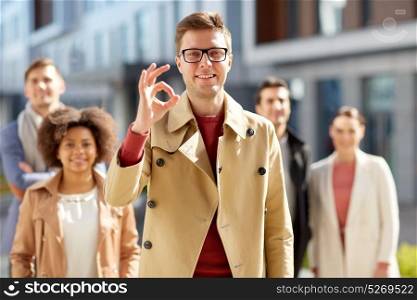 business, gesture and corporate concept - happy smiling man with international group of people showing ok hand sign outdoors. happy smiling man showing ok hand sign outdoors