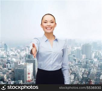 business, gesture and education concept - friendly young smiling businesswoman with opened hand ready for handshake