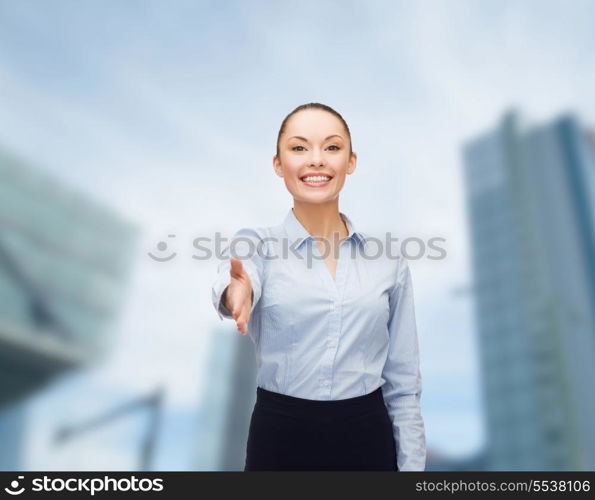 business, gesture and education concept - friendly young smiling businesswoman with opened hand ready for handshake