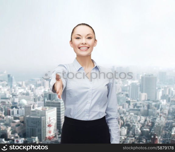 business, gesture and education concept - friendly young smiling businesswoman with opened hand ready for handshake