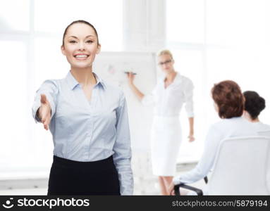 business, gesture and education concept - friendly young smiling businesswoman with opened hand ready for handshake