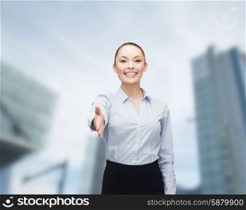 business, gesture and education concept - friendly young smiling businesswoman with opened hand ready for handshake