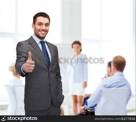 business, gesture and office concept - handsome buisnessman showing thumbs up in office