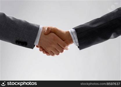 business, gesture and partnership concept - handshake of two businessmen over grey background. handshake of two businessmen