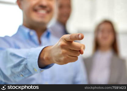 business, gesture and people concept - close up of smiling businessman pointing finger. close up of smiling businessman pointing finger