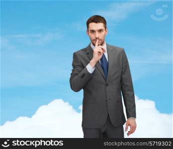 business, gesture and people concept - young businessman making hush sign over blue sky background over blue sky with white cloud background