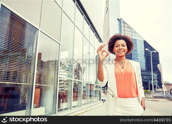 business, gesture and people concept - young smiling african american businesswoman in city showing ok hand sign
