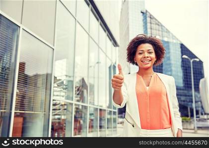 business, gesture and people concept - young smiling african american businesswoman in city showing thumbs u p