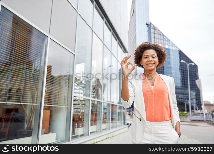 business, gesture and people concept - young smiling african american businesswoman in city showing ok hand sign