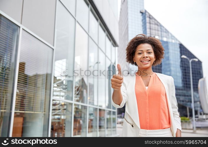 business, gesture and people concept - young smiling african american businesswoman in city showing thumbs u p