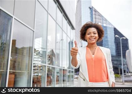 business, gesture and people concept - young smiling african american businesswoman in city showing thumbs u p