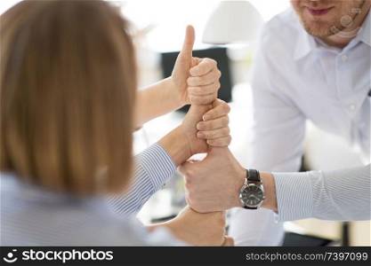 business, gesture and teamwork concept - close up of businesspeople making thumbs up. group of business team making thumbs up gesture
