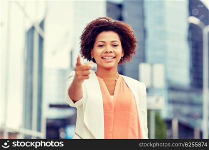business, gesture, hiring and people concept - young smiling african american businesswoman pointing finger on you in city