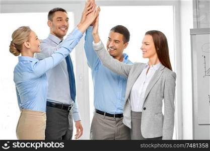 business, gesture, people and teamwork concept - happy creative team making high five at office. happy business team making high five at office