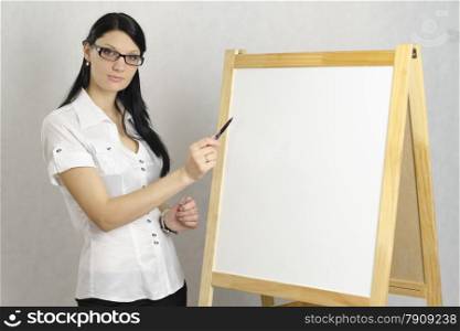 Business girl with glasses shows a marker on a white board