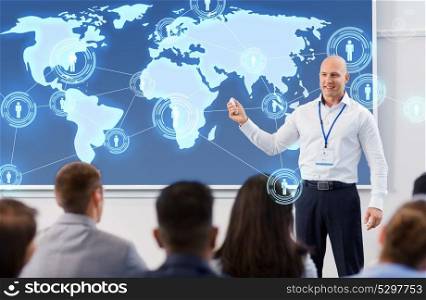 business, global network and people concept - smiling businessman or lecturer with world map on projection screen and group of students at conference presentation or lecture. group of people at world business conference