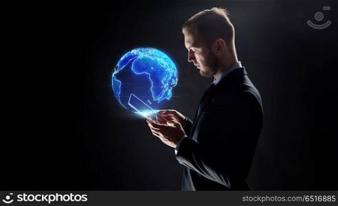 business, globalization and future technology concept - businessman with transparent tablet pc computer and earth hologram over black. businessman with tablet pc and earth hologram. businessman with tablet pc and earth hologram