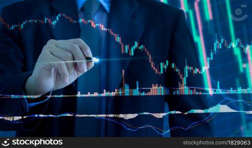 Business graph and chart stock market or forex trading with financial investment. businessman holding pen touching on a virtual screen.. Business graph and chart stock market or forex trading