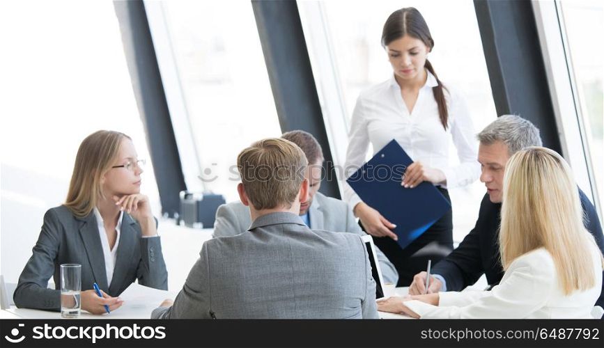 Business group at meeting. Business person group in formalwear discuss documents at meeting in modern office
