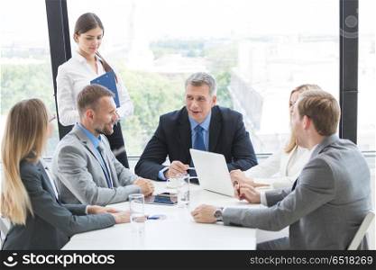 Business group at meeting. Business person group in formalwear discuss documents at meeting in modern office