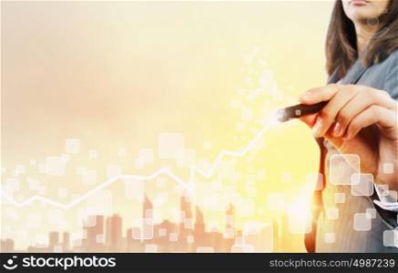 Business growth. Chest view of businesswoman drawing with pencil increasing graph