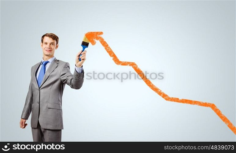 Business growth. Handsome businessman with paint brush in hand