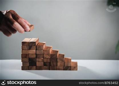Business hand arranging put wooden block stacking step stair growth success process, financial risk management and strategic plan and business challenge planning concept, prevent collapse or crash