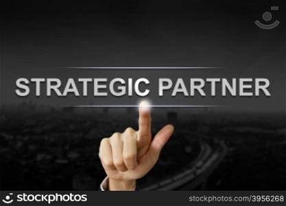 business hand clicking strategic partner button on black blurred background