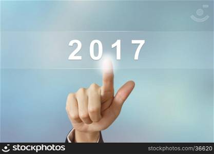 business hand pushing 2017 button on blurred background