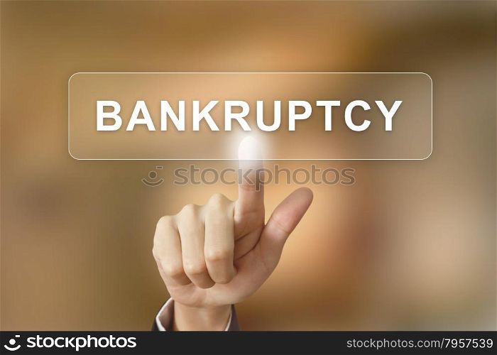 business hand pushing bankruptcy button on blurred background