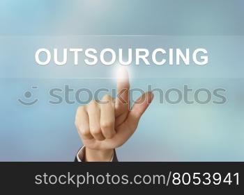 business hand pushing outsourcing button on blurred background