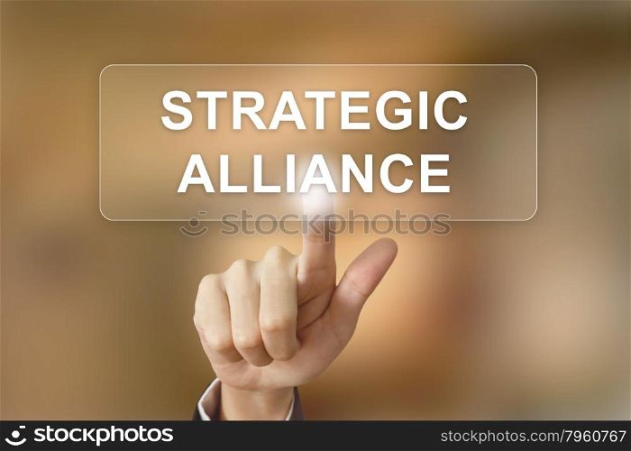 business hand pushing strategic alliance button on blurred background