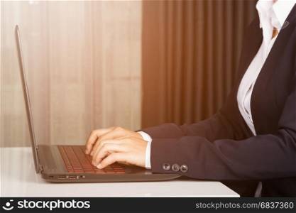 business hands with laptop typing in sunlight