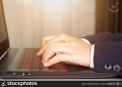 business hands with laptop typing in sunlight