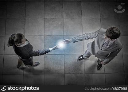 Business handshake. Top view of a businessman and woman shaking hands in office lobby
