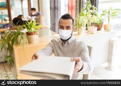 business, health and people concept - businessman or creative male office worker wearing face protective medical mask for protection from virus disease giving folder. creative male office worker in mask with folder