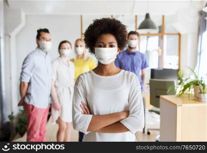 business, health and people concept - young african american woman over creative team wearing face protective medical mask for protection from virus disease at office. woman in mask over creative team at office