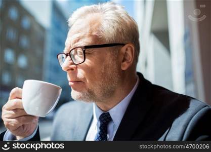 business, hot drinks, break and people and concept - senior businessman drinking coffee from cup on city street