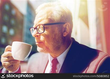 business, hot drinks, break and people and concept - senior businessman drinking coffee from cup on city street. senior businessman drinking coffee on city street