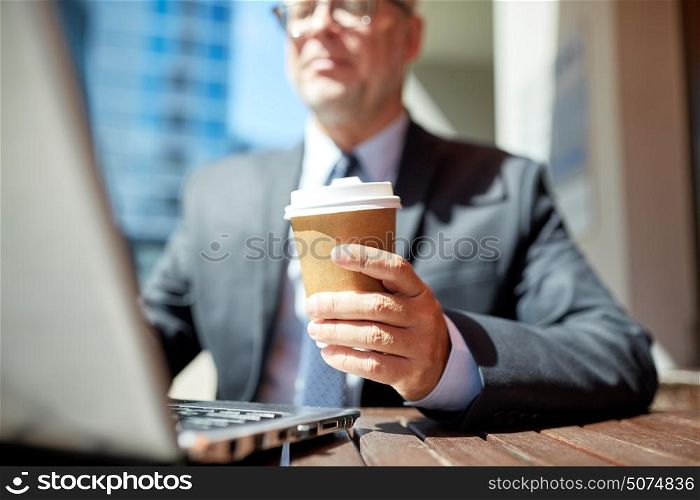 business, hot drinks, break and people and concept - senior businessman with laptop computer drinking coffee from paper cup outdoors. senior businessman with laptop and coffee outdoors