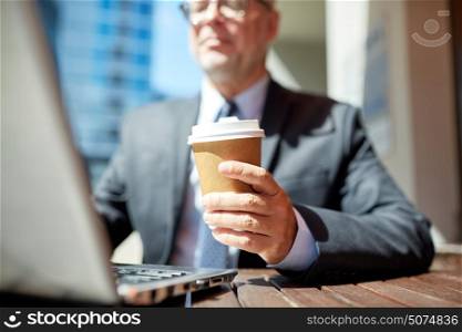 business, hot drinks, break and people and concept - senior businessman with laptop computer drinking coffee from paper cup outdoors. senior businessman with laptop and coffee outdoors