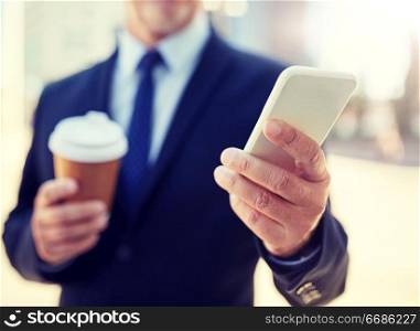 business, hot drinks, break and people and concept - senior businessman with smartphone drinking coffee from disposable paper cup outdoors. senior businessman with smartphone and coffee