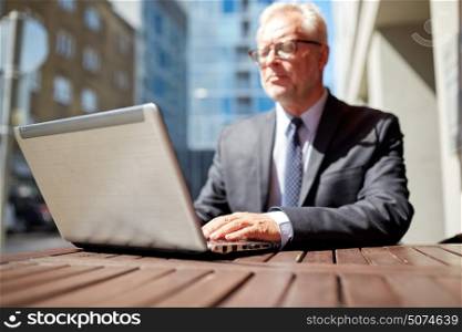business, hot drinks, technology and people and concept - senior businessman with laptop computer at outdoor cafe. senior businessman with laptop at outdoor cafe