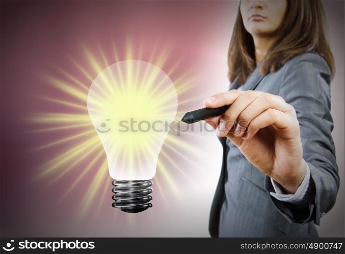 Business idea. Close up of businesswoman drawing bulb with pen
