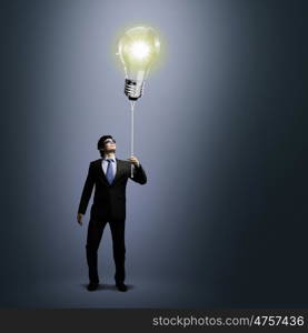 Business idea. Image of businessman with bulb balloon. Inspiration concept