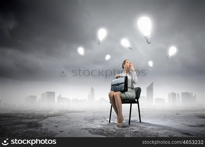Business idea. Image of businesswoman sitting on chair with suitcase in hands
