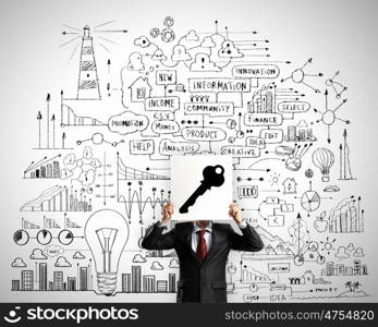 Business ideas. Businessman hiding his face with sheet of paper with sketches at background